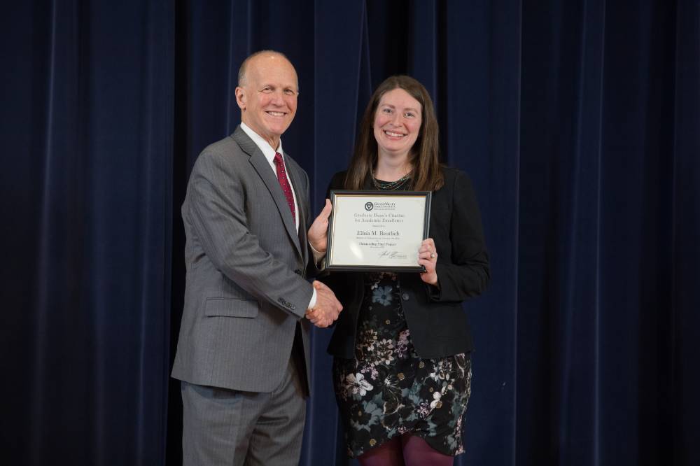Graduate Student posing for a photo with Dean Potteiger and their award